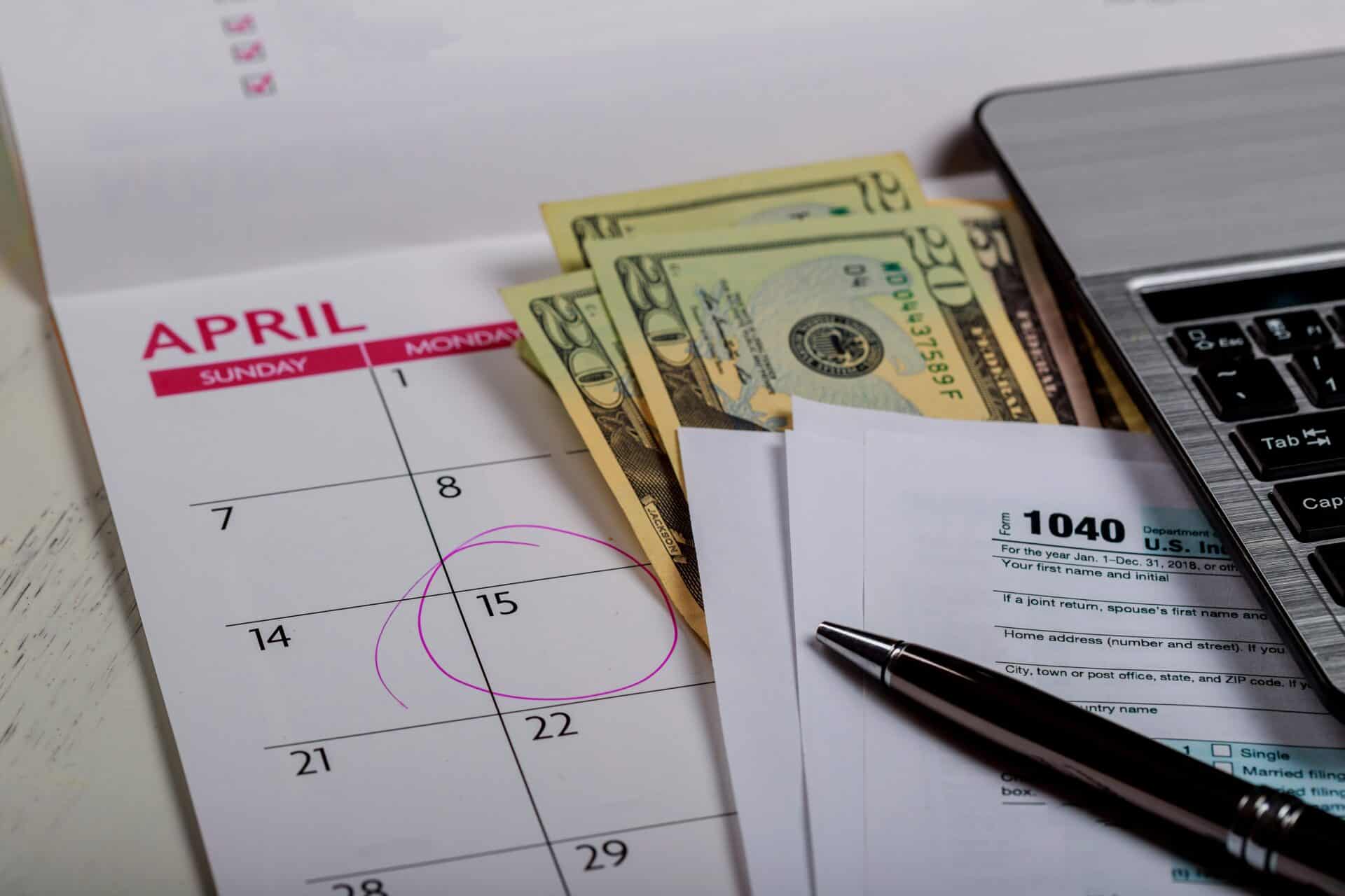 1040 us tax form, money and calendar with u.s dollars money and computer