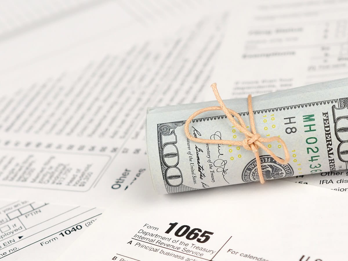 1065 u.s. return of parentship income form with roll of american dollar banknotes