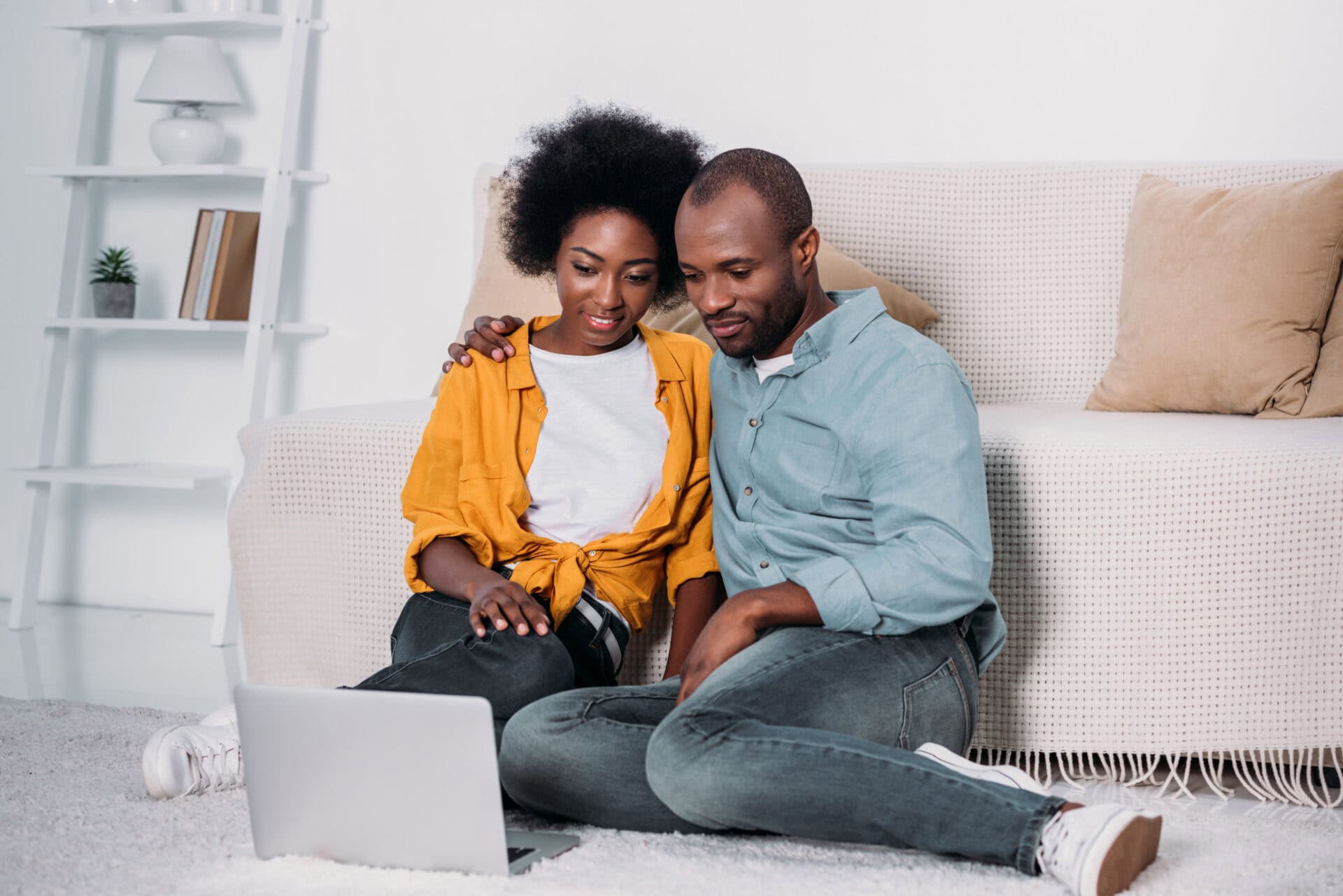 african american couple watching film on laptop at home
