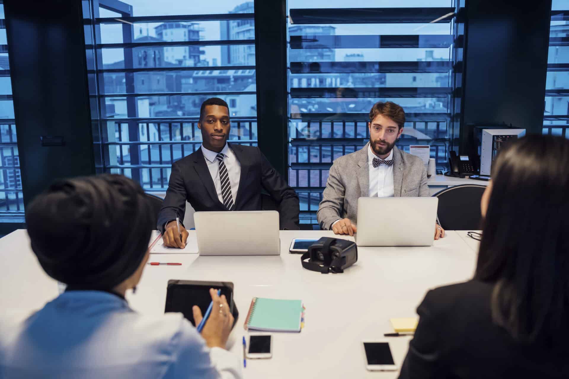 businessmen listening at conference table meeting