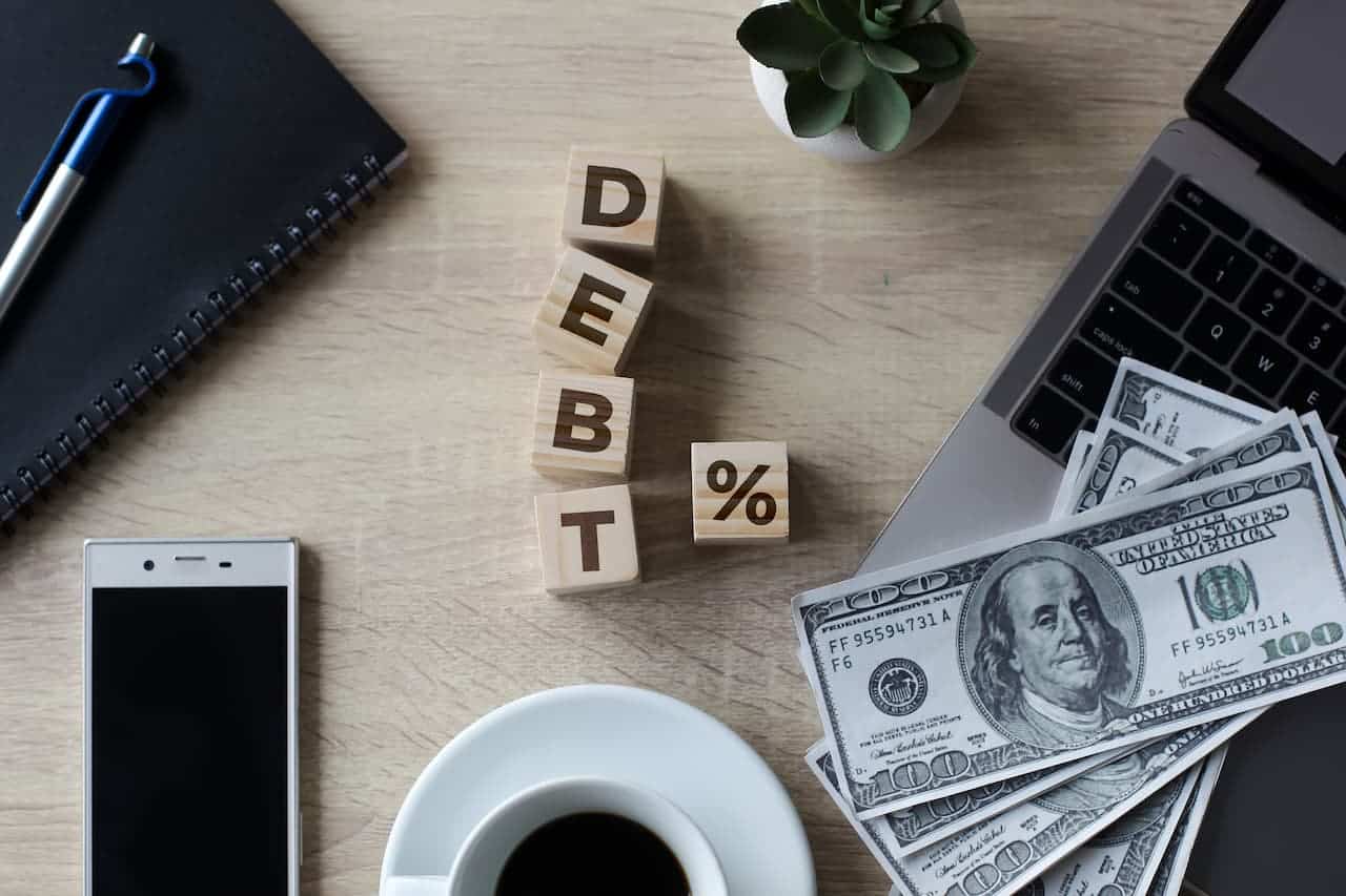 A desk containing blocks of letters spelling the word debt