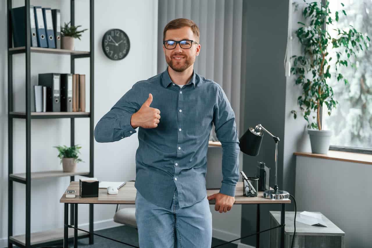 A man standing at his office smiling