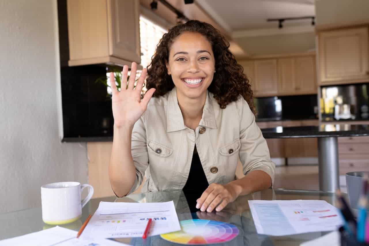 A happy young woman with her right hand up