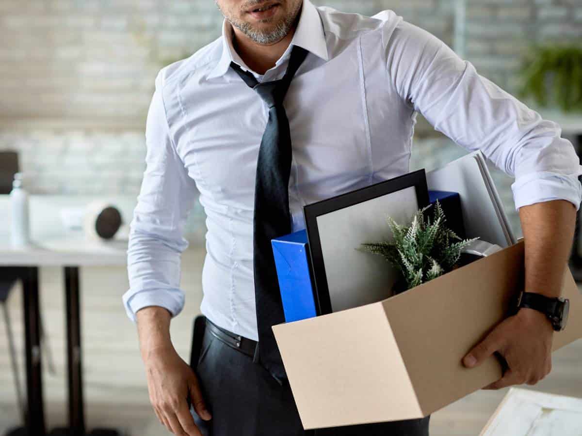 sad male entrepreneur carrying his belongings after layoff