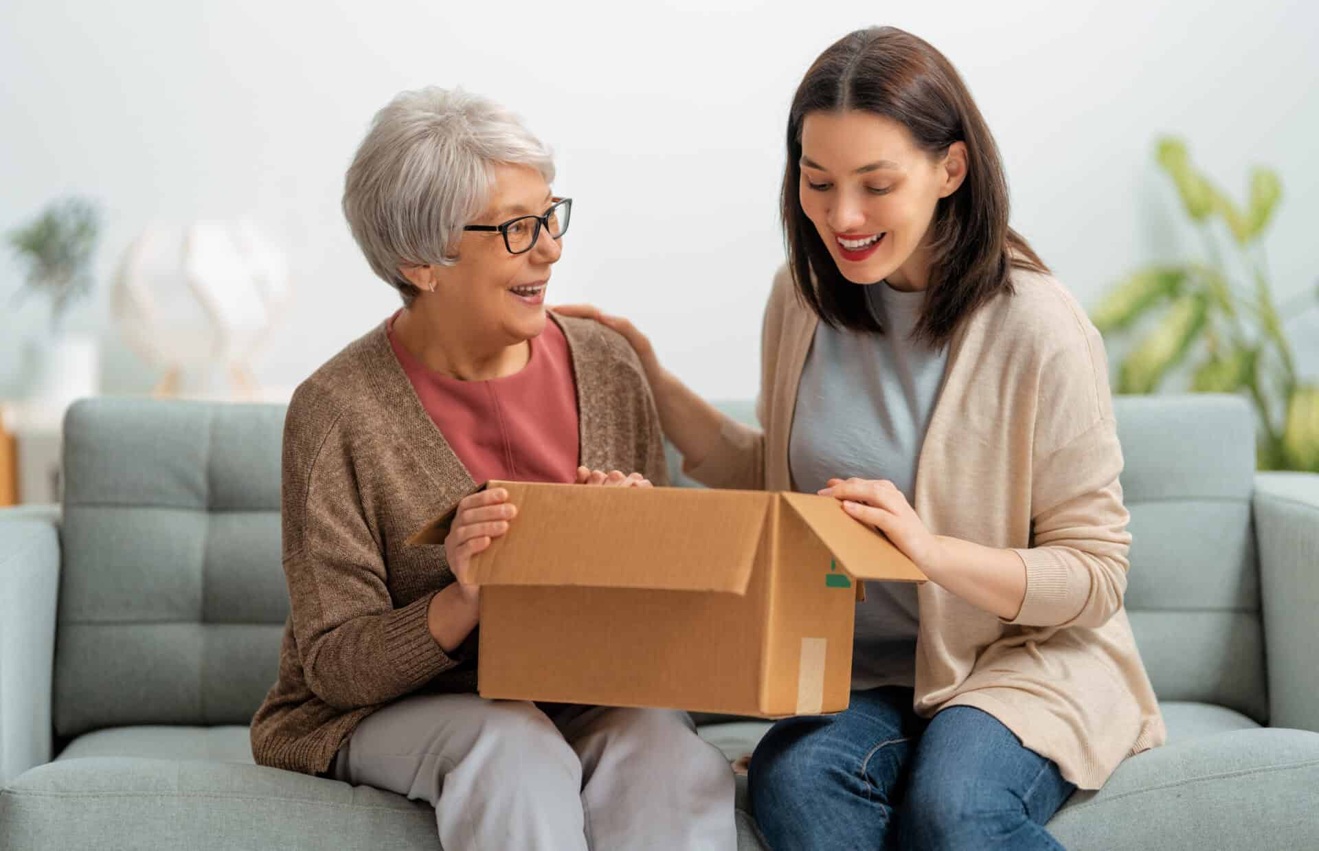 women are holding cardboard box