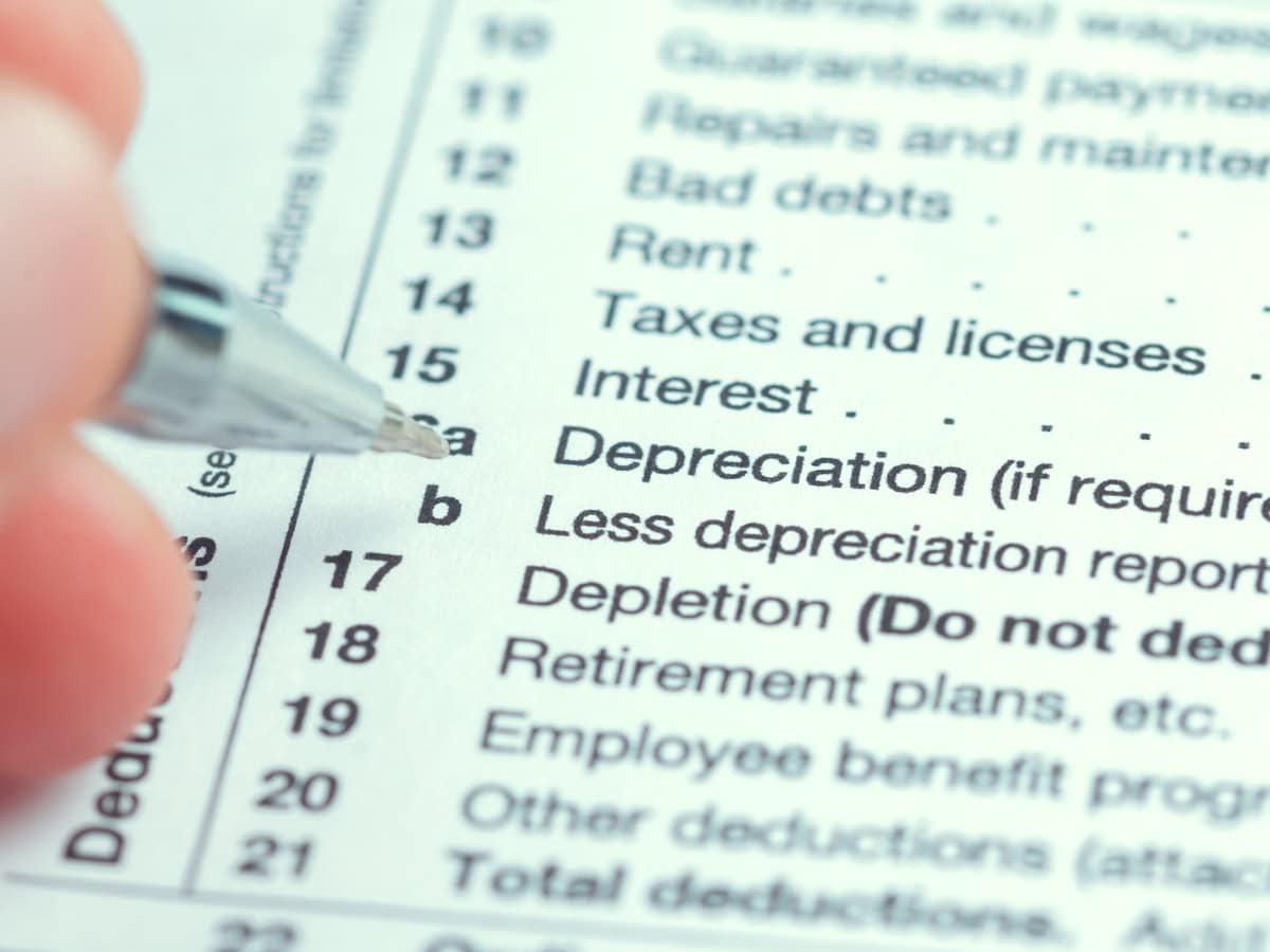 writing on a tax form to complete financial information during t