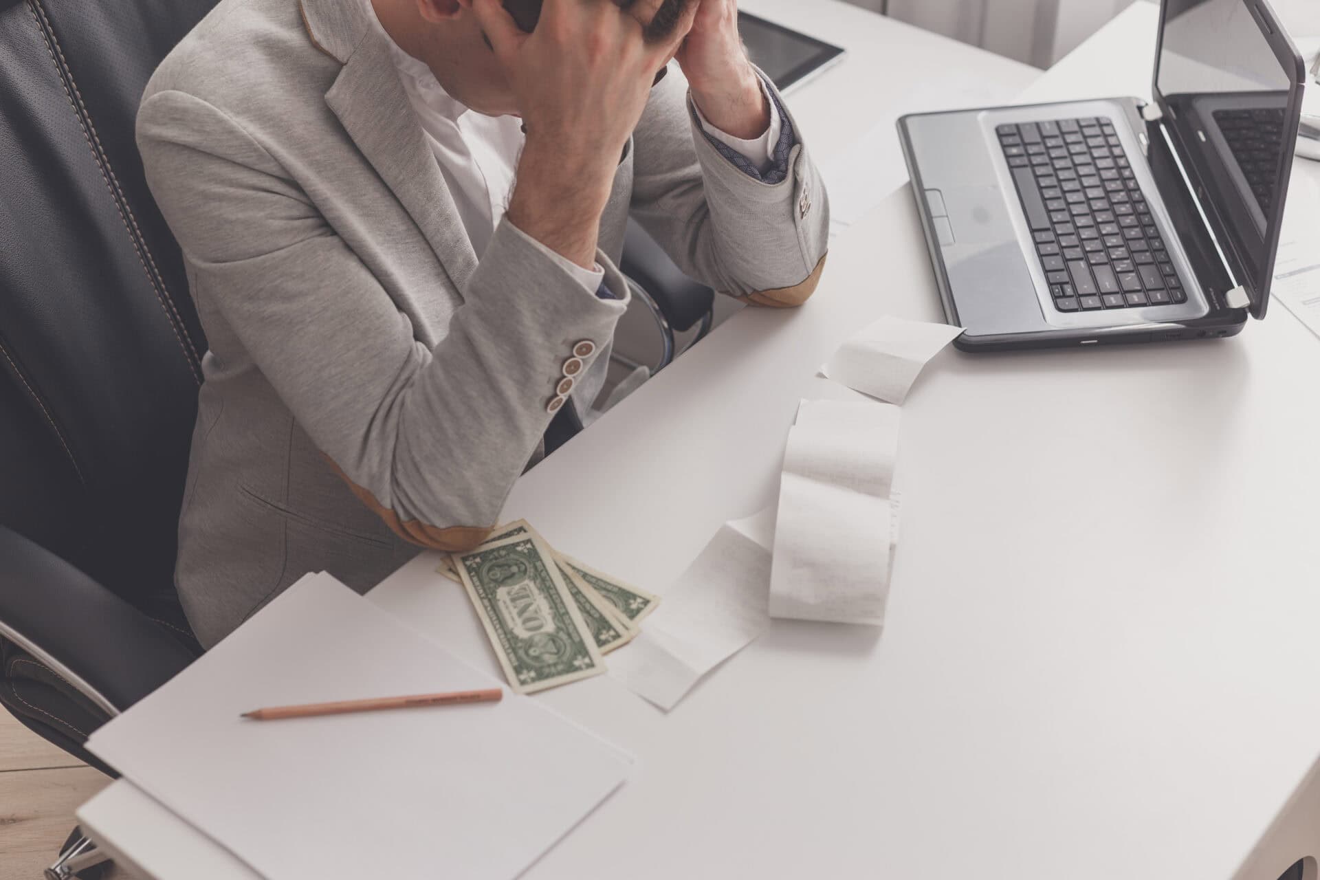 young man frustrated at his house by debt